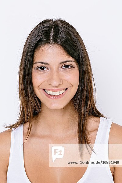 Portrait of young woman wearing white vest looking at camera smiling