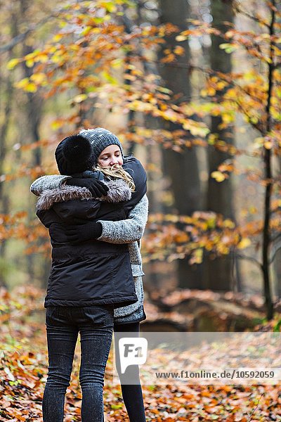 Girls hugging in autumn forest