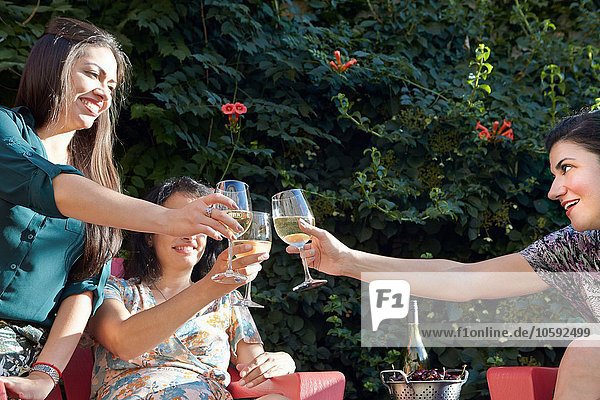 Drei Frauen mit Weißwein auf der Terrasse
