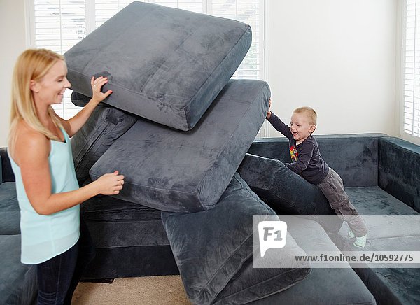 Boy pushing over cushions in living room