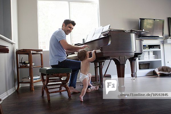 Father and baby boy playing on piano