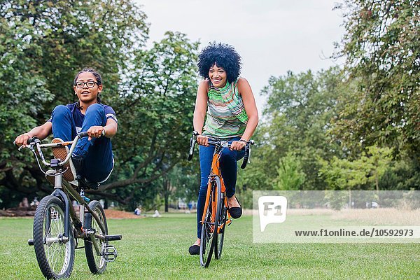 Front view of mother and son riding on bicycles smiling