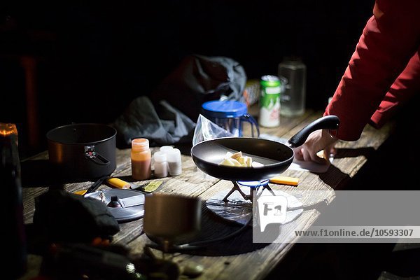 Hiker preparing dinner at camp