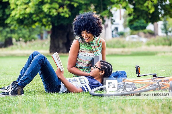 Junge und Mutter lesen und entspannen im Park