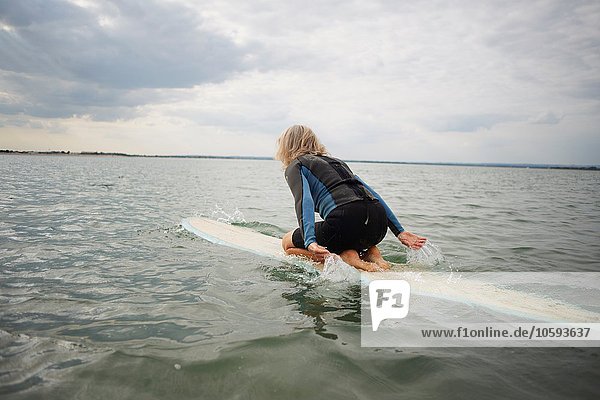 Seniorin auf dem Surfbrett im Meer  Paddleboarding