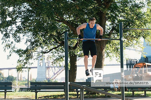 Young man exercising using bar