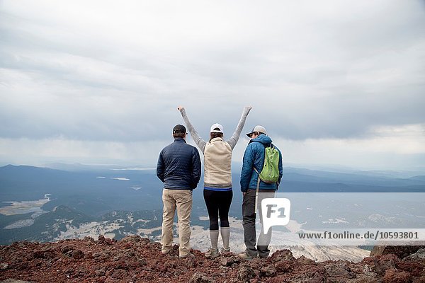 Three friends standing at the summit of South Sister volcano  looking at view  Bend  Oregon  USA
