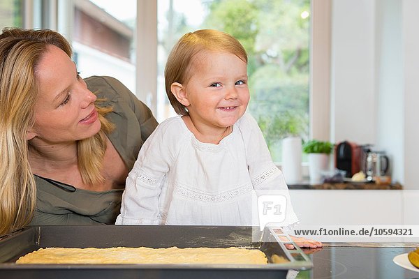 Portrait of female toddler and mother in kitchen
