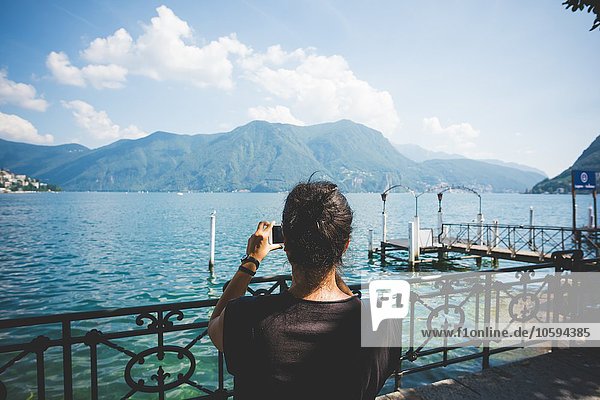 Rückansicht der mittleren erwachsenen Frau beim Fotografieren mit Smartphone  Luganer See  Schweiz