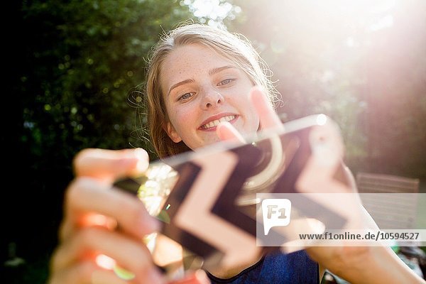 Teenager Mädchen nimmt Smartphone Selfie in den Park