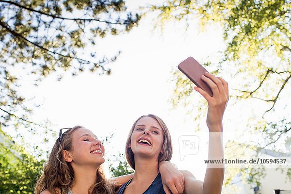 Zwei Teenager-Mädchen im Park nehmen Smartphone Selfie