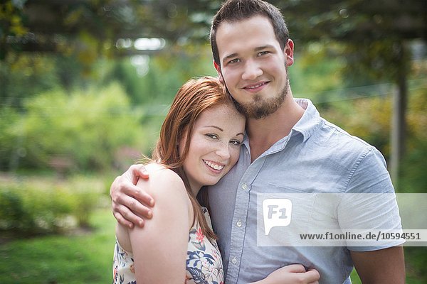 Portrait of couple hugging  looking at camera smiling