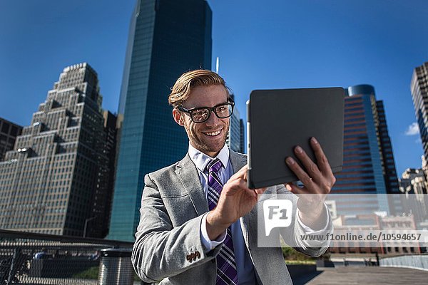 Jungunternehmer mit digitalem Tablett-Touchscreen vor dem Büro New York USA