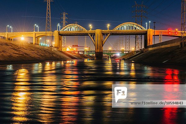 Abnehmende Perspektive von Los Angeles River und 6th Street Bridge bei Nacht beleuchtet  Los Angeles  Kalifornien  USA