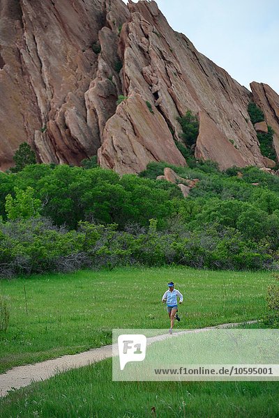 Female trail runner running along dirt track  Colorado Front Range  Boulder  USA