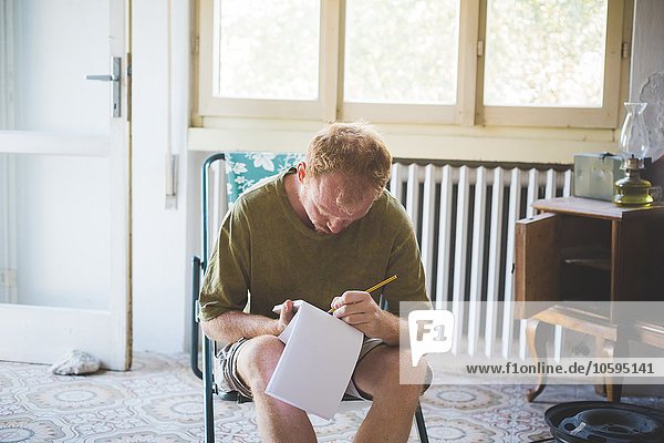 Man writing notes in room