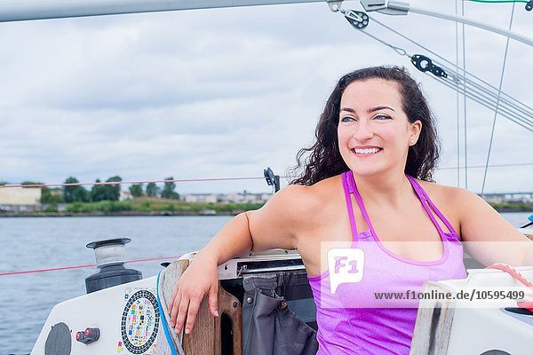 Young woman wearing vest on sailboat looking away smiling