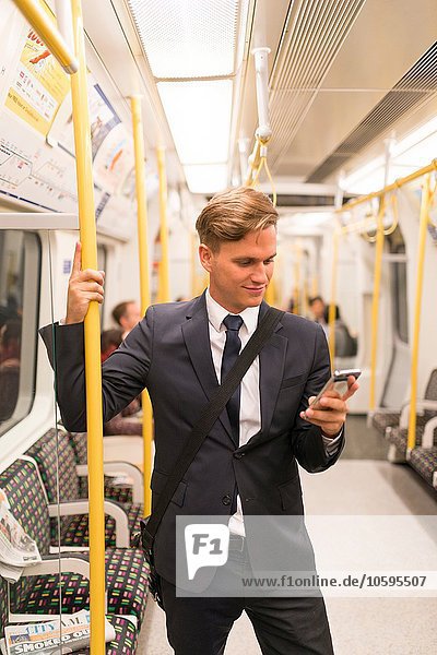 Geschäftsmann texting on tube  London Underground  UK