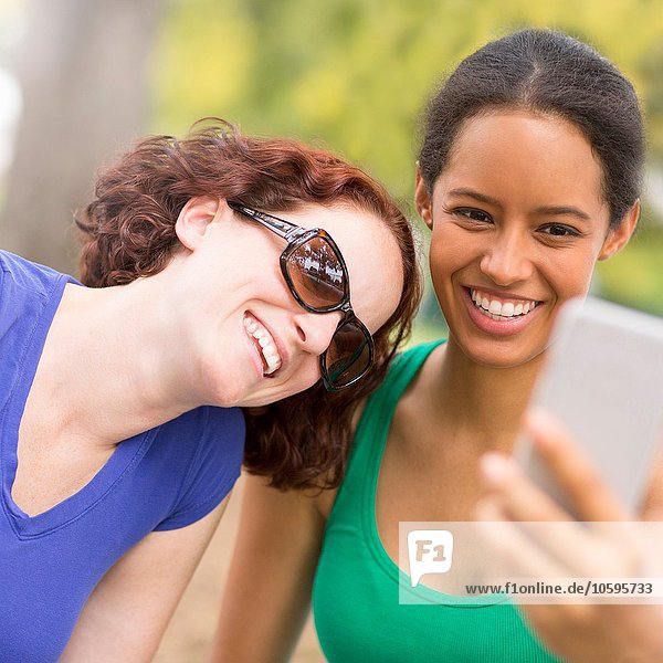 Junge Frauen benutzen Smartphone  um Sefie lächelnd zu nehmen.