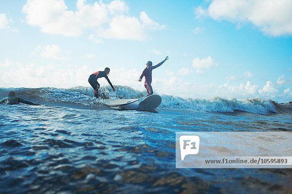 Zwei Surfer surfen im Meer