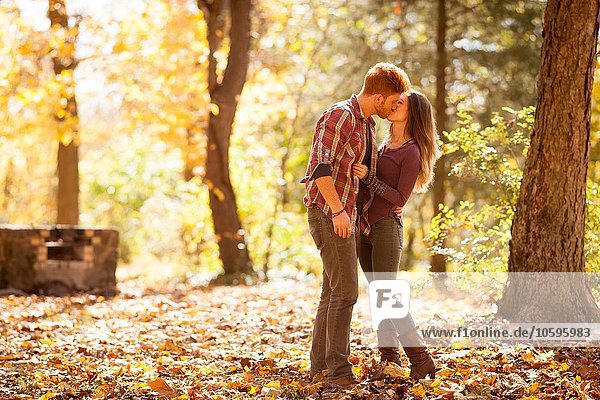 Young couple kissing in autumn forest