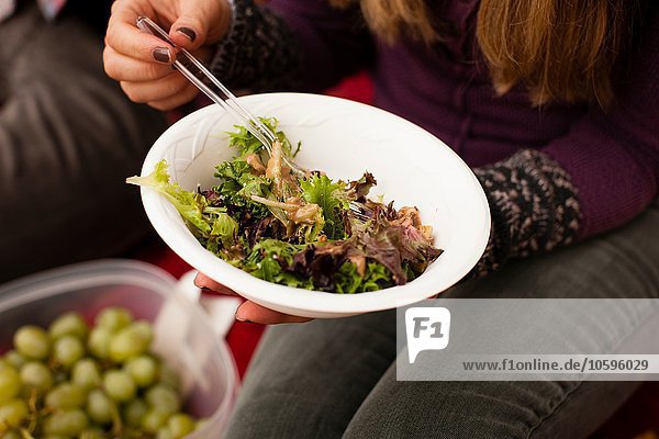 Ausschnitt eines jungen Paares  das Picknick-Salat isst.