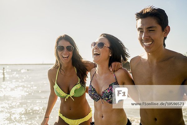 Three young adult friends strolling on Newport Beach  California  USA