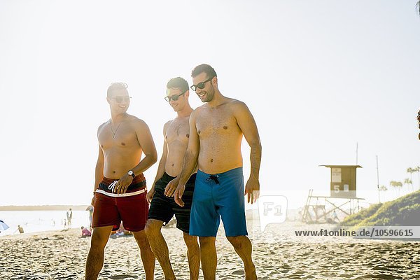 Drei junge männliche Freunde beim Spaziergang am Newport Beach  Kalifornien  USA