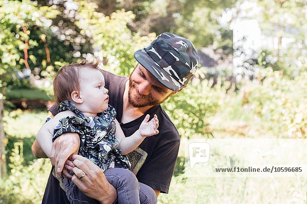 Mittlerer erwachsener Mann mit Baby-Tochter im Wald