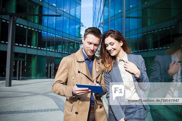 Geschäftsmann und Frau mit digitalem Tablett