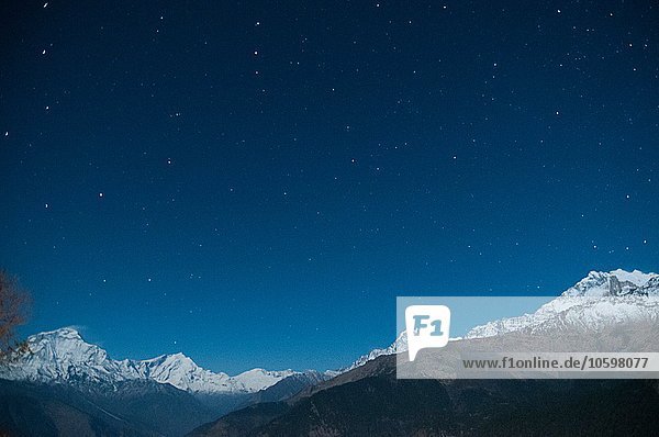 Schneebedeckte Bergkette unter Sternenhimmel  Nepal