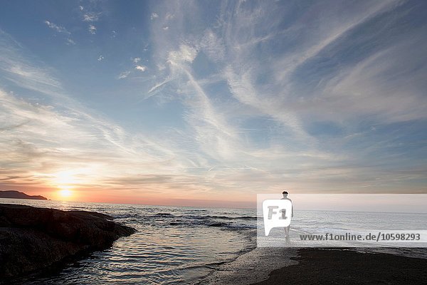 Rückansicht des reifen Mannes am Strand bei Sonnenuntergang  Calvi  Korsika  Frankreich