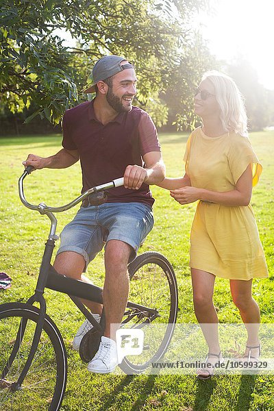Junges Paar beim Radfahren im sonnigen Park