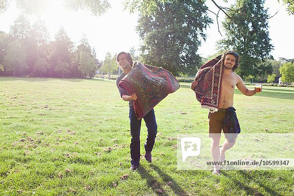 Zwei junge Männer mit Teppichen für die Sunset-Park-Party