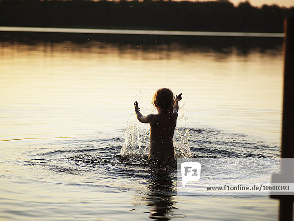 Girl splashing water in lake