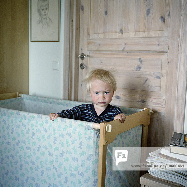 Junge im Kinderbett stehend  Porträt
