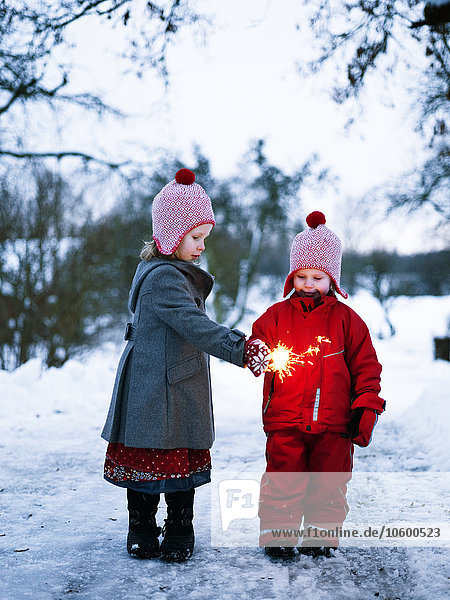 Girls in winter playing with sparkler