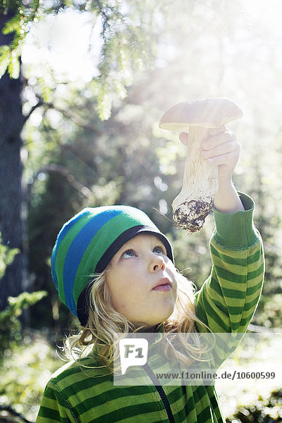 Girl holding mushroom against sunlight