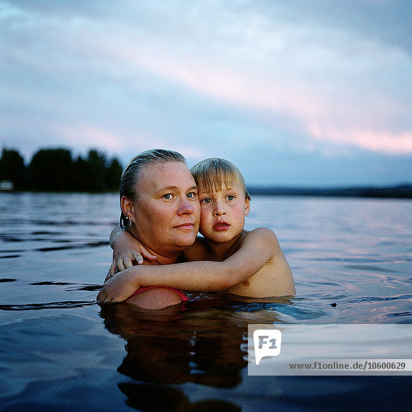 Mutter und Sohn im See am Abend