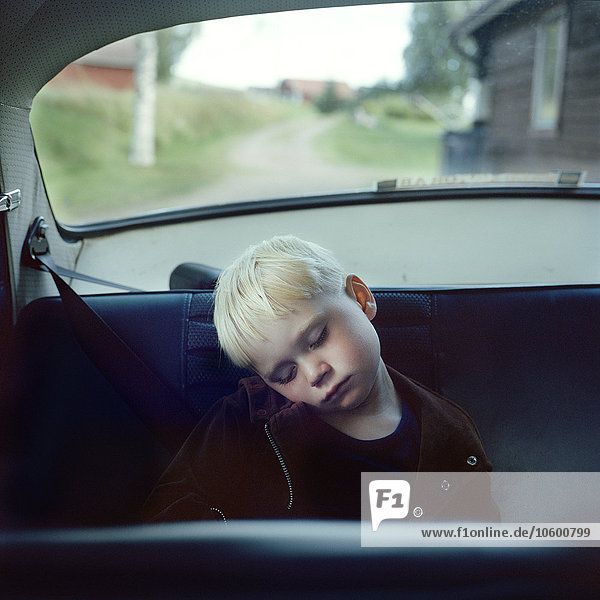 Schlafender Junge auf dem Rücksitz eines Autos