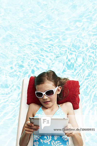 Mädchen mit Tablet-PC auf Pool-Floß