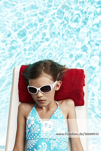 Mädchen entspannt sich auf einem Floß im Pool