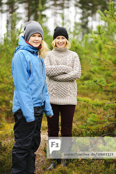 Zwei lächelnde Frauen stehen im Wald
