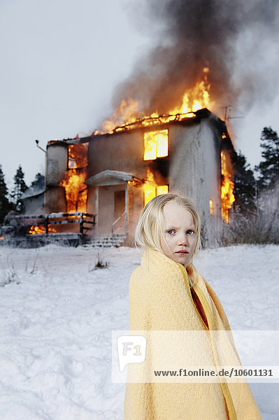 Gerettetes Mädchen vor brennendem Haus