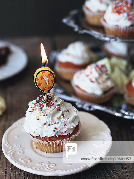 Frosted Cupcake mit brennender Geburtstagskerze