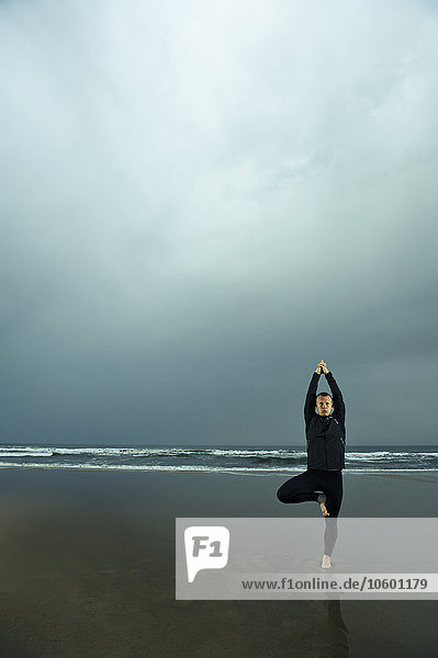 Man doing yoga at beach