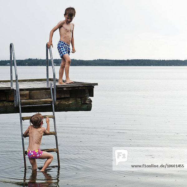 Zwei Jungen auf einem Steg am Meer
