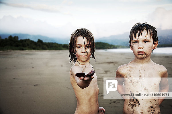 Zwei Brüder spielen am Strand