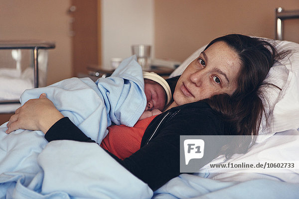 Mutter mit neugeborenem Baby im Krankenhausbett