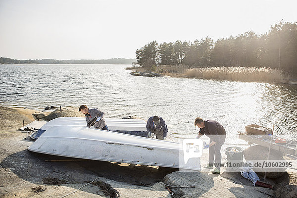 Junge Männer streichen Boot